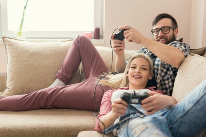 Boyfriend learning his girlfriend to play video games on